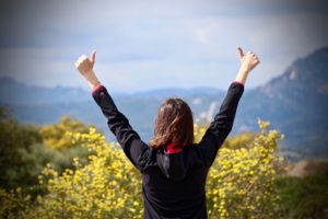 woman persevered, raised arms, thumbs up