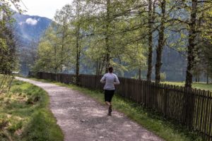 learn how to persevere, woman running along a tree-lined path